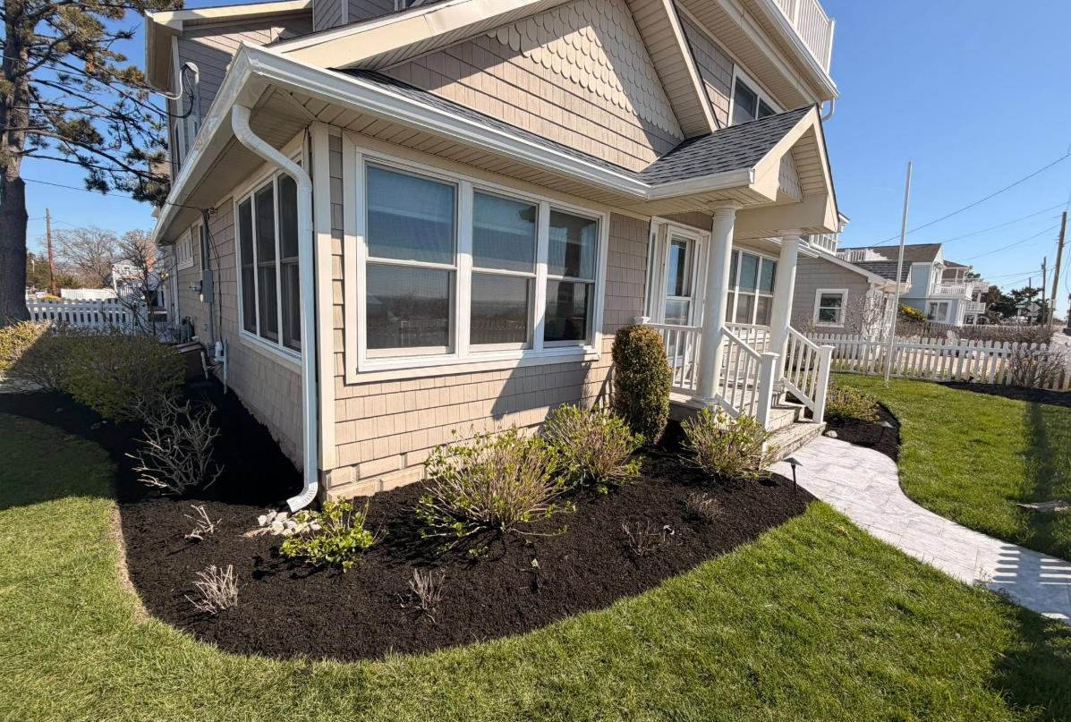 Coastal home with fresh mulch beds and paver walkway